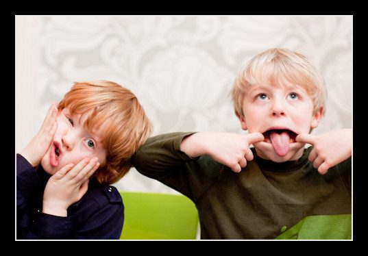 Two boys pulling silly faces, family portrait, Richmond, London