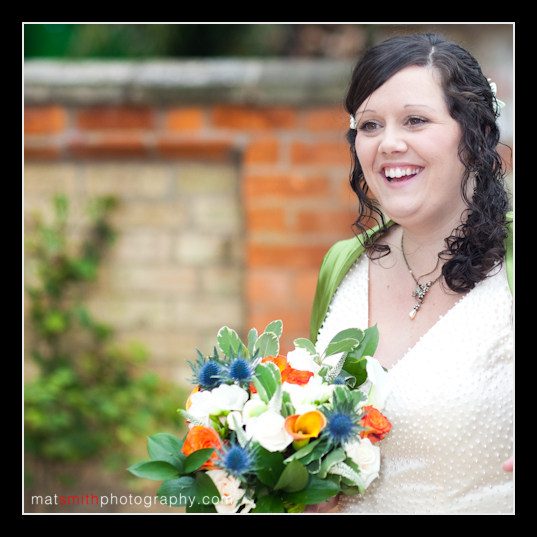 Anna smiling with her wedding flowers, bridal portrait by Mat Smith Photography, Gloucestershire