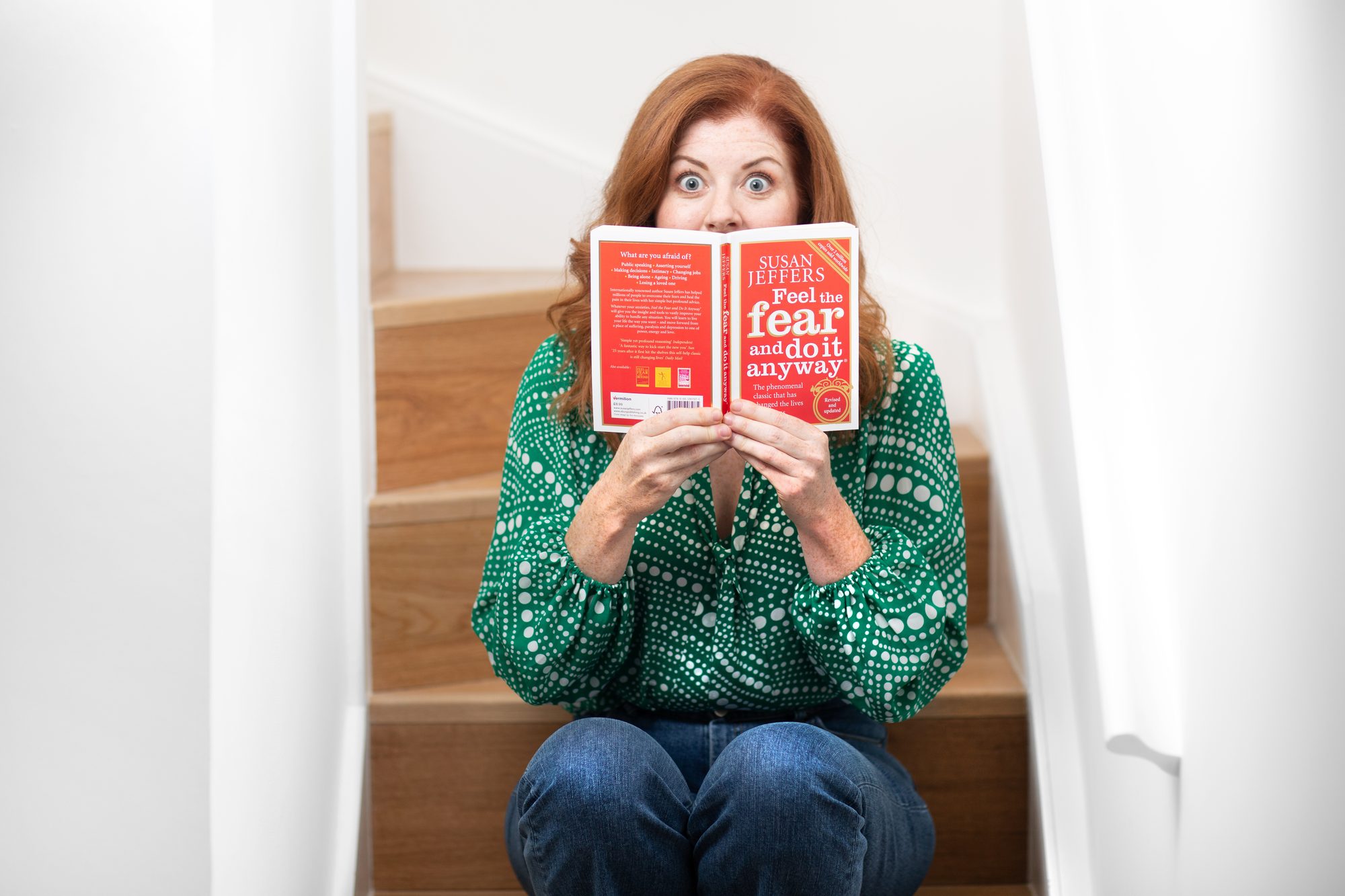 Marianne Power, author of Help Me, peeping over her book, portrait by Mat Smith Photography, Homerton