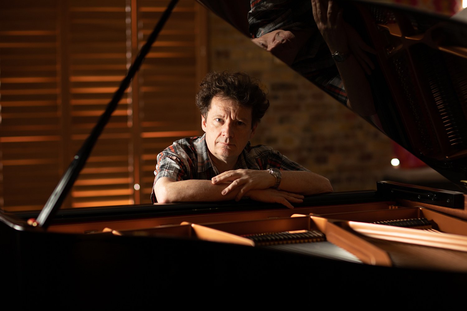 Composer and pianist at a grand piano