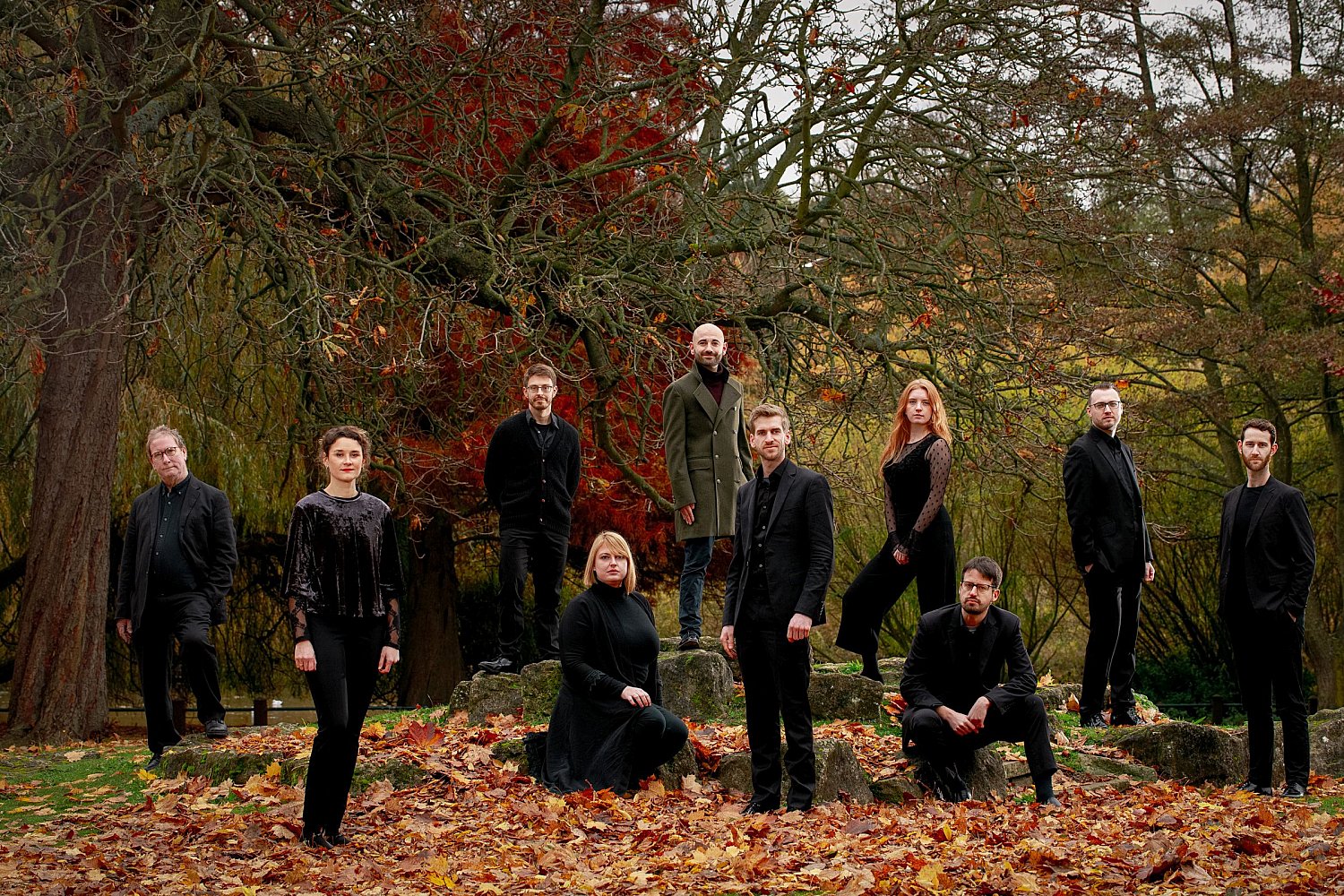 Opera Settecento ensemble among fallen leaves in an autumn wood